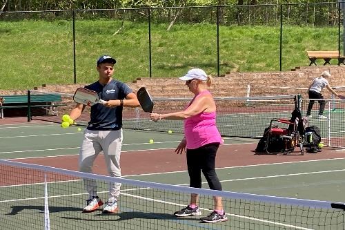 Instructor teaching player at pickleball clinic