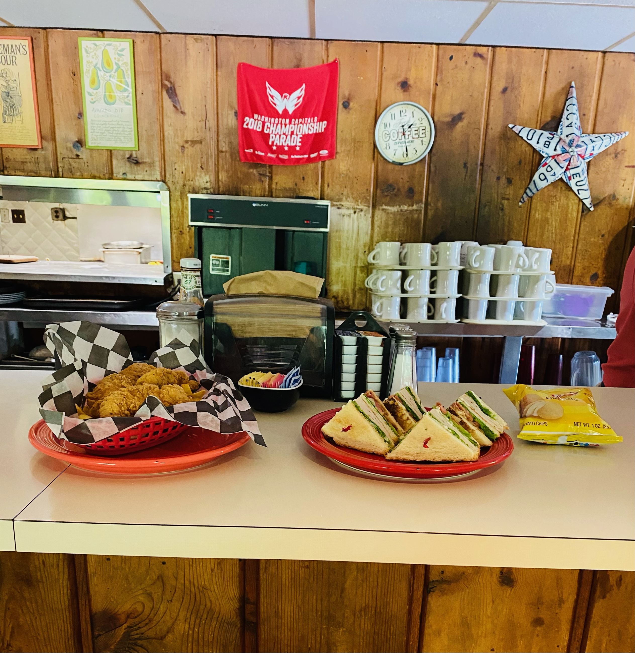Counter with tenders and fries and a turkey BLT with chips