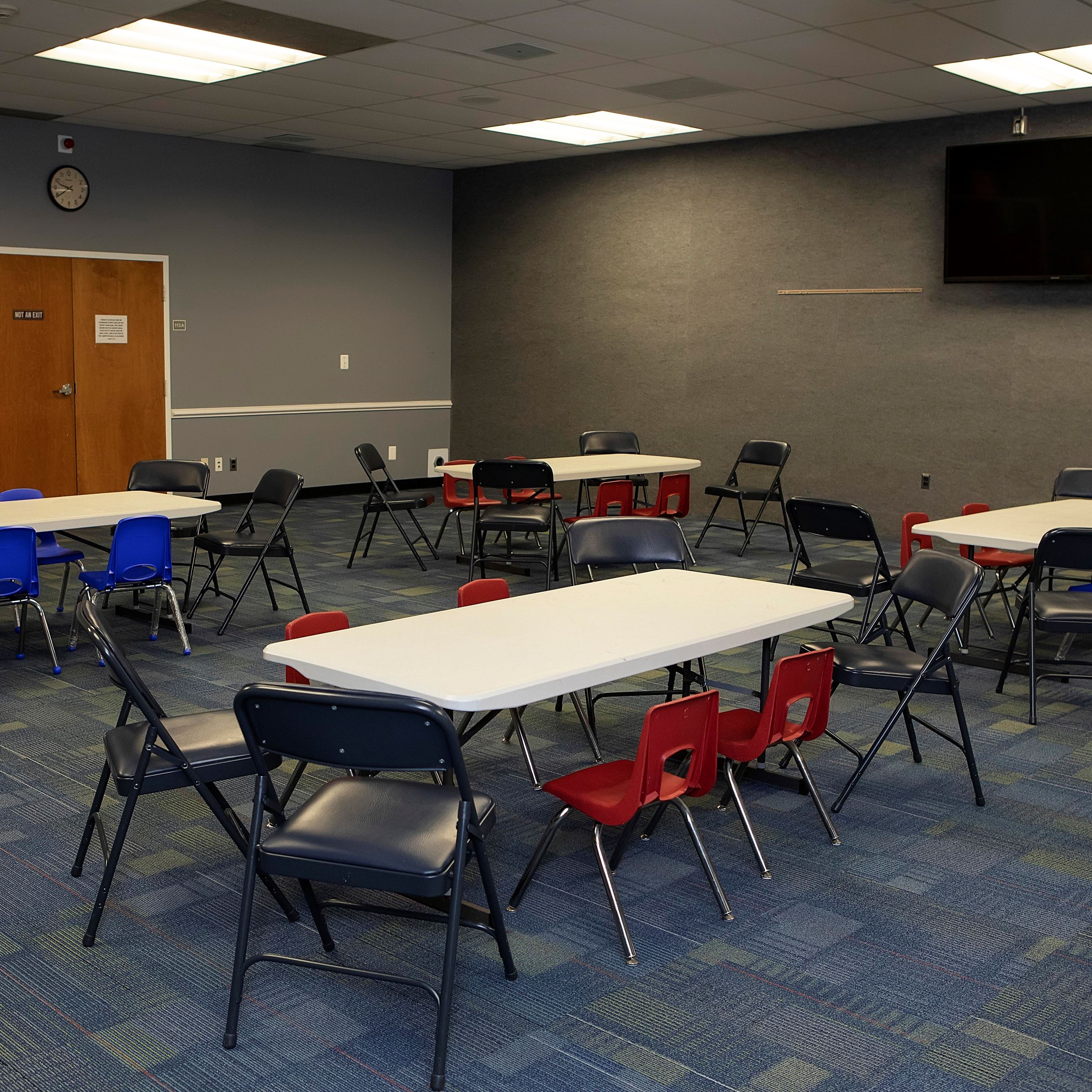 Harriet E. Brown meeting room with tables, chairs and a TV