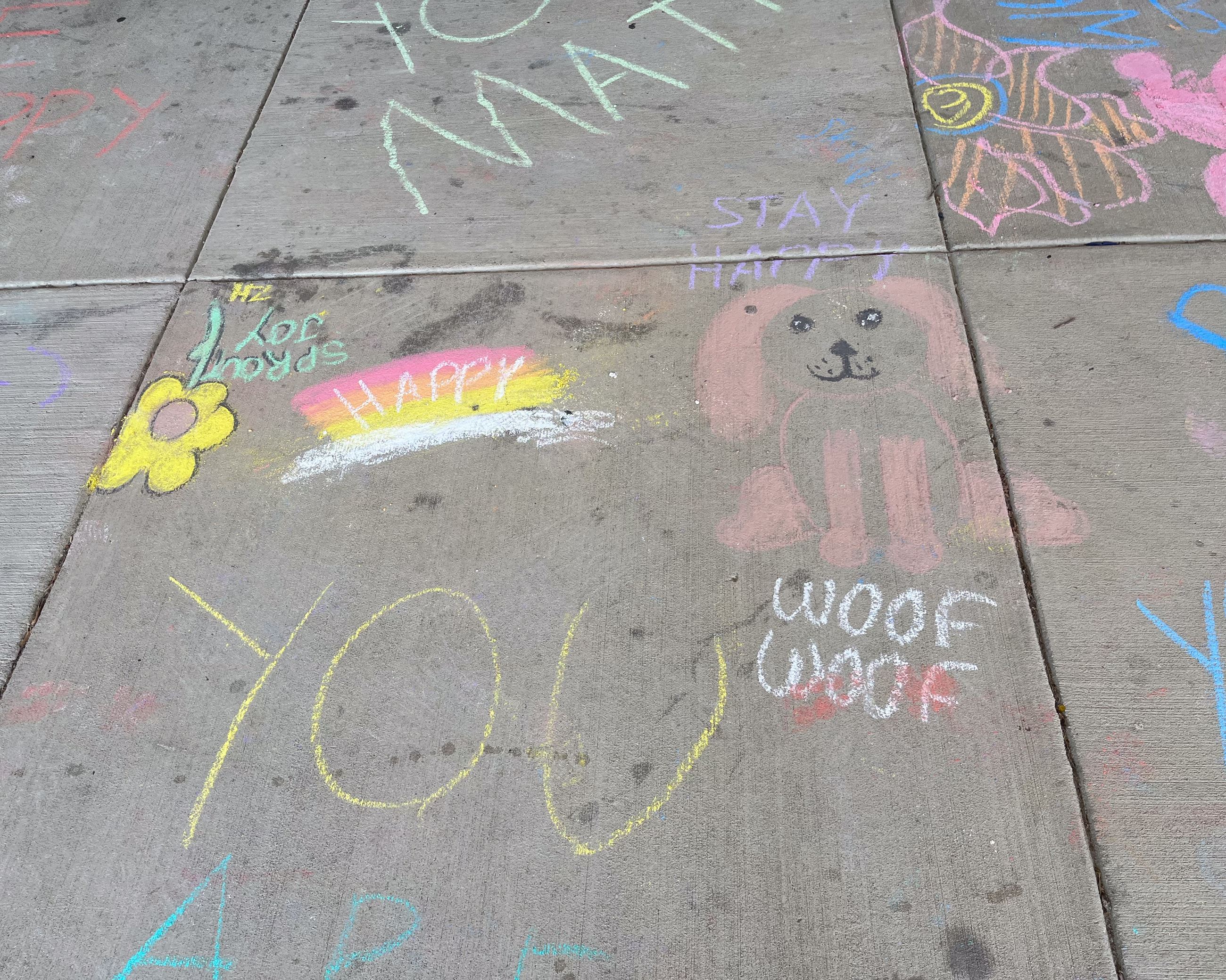 Multicolored sidewalk chalk art with text "Take a break." and other text upside down.