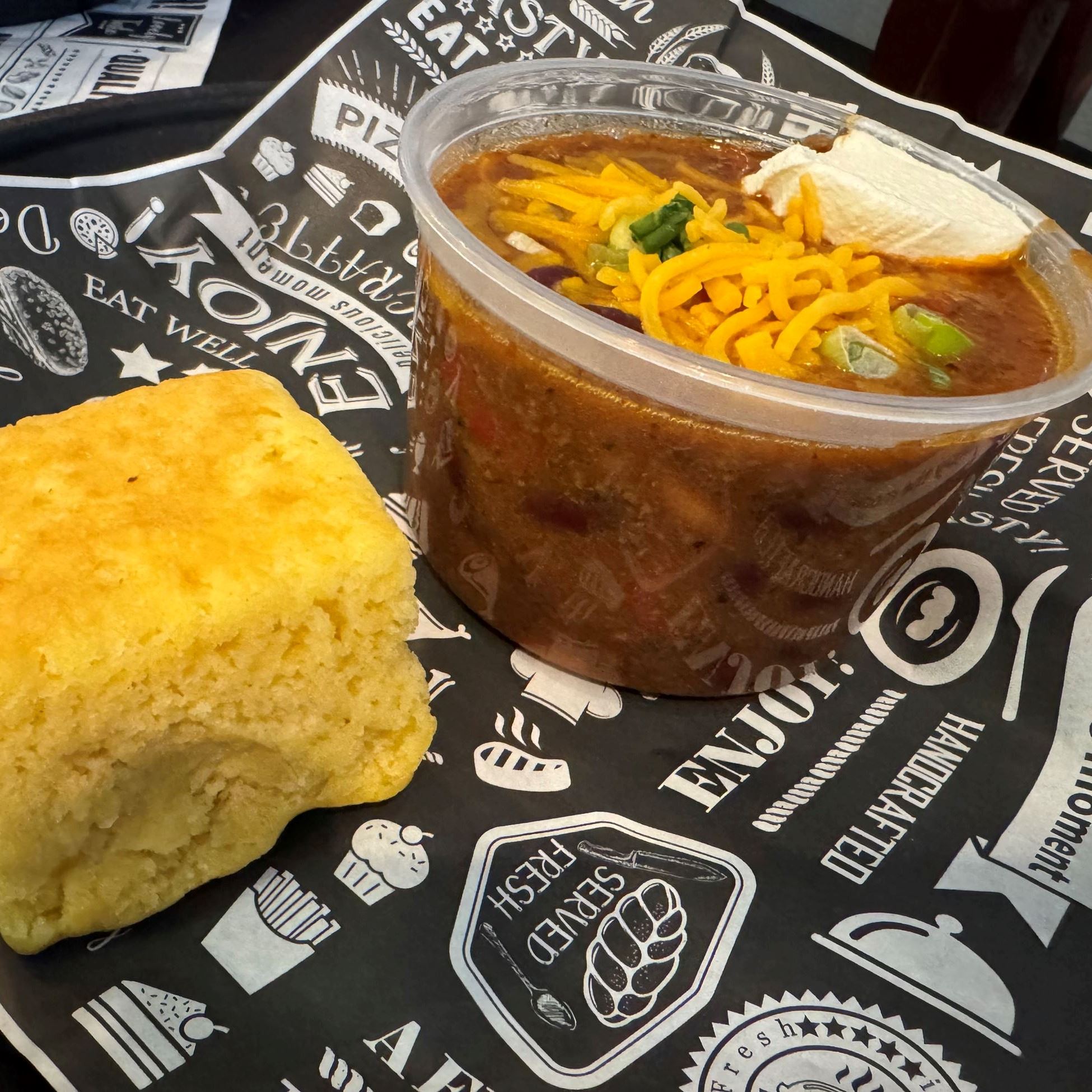 cup of chili with cheese and cornbread